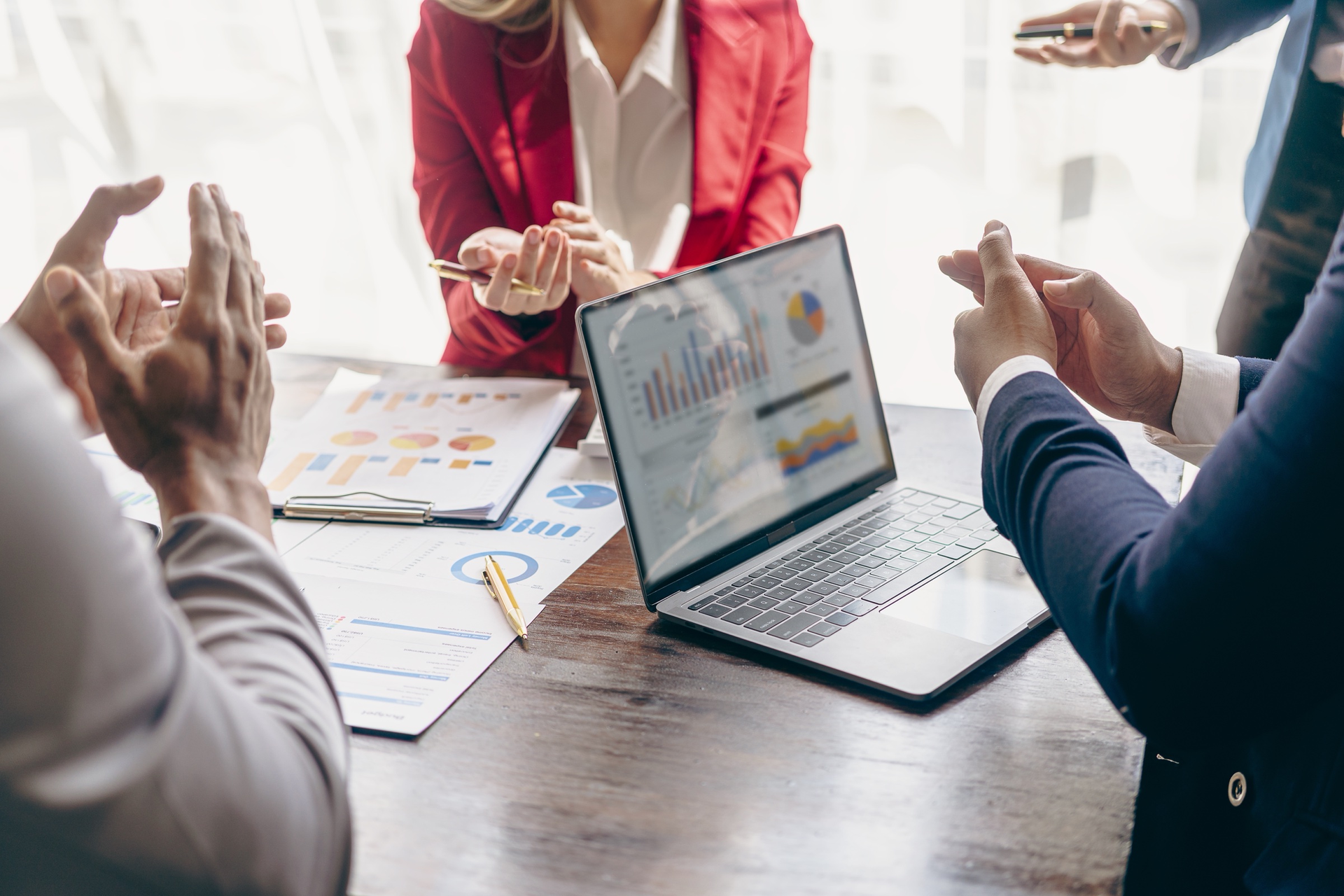 Business owners and a consultant reviewing growth charts on a laptop in an informal meeting
