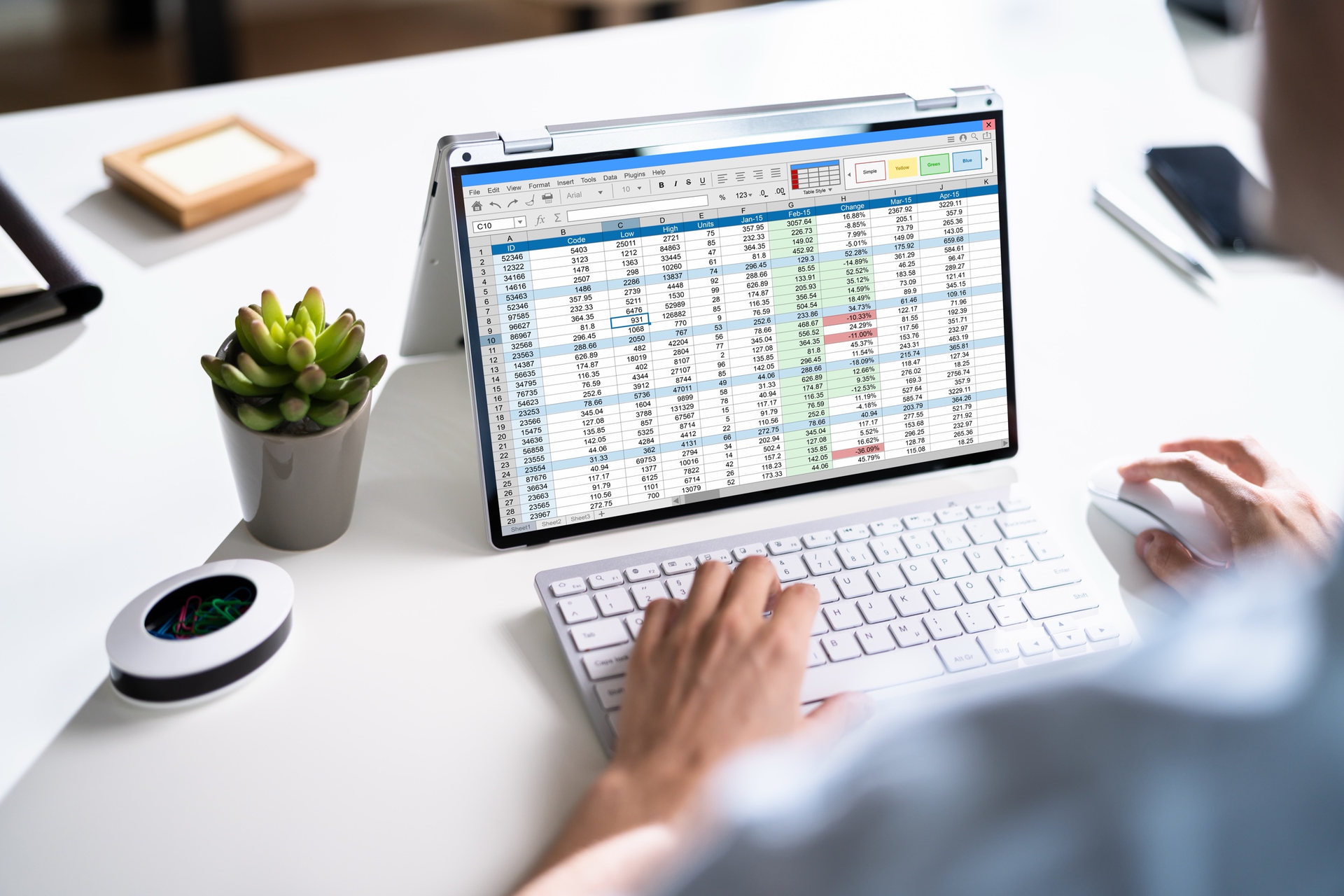 Dense spreadsheet open on a laptop screen at an office desk